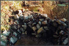 The berm at the hatchery pond before the slide